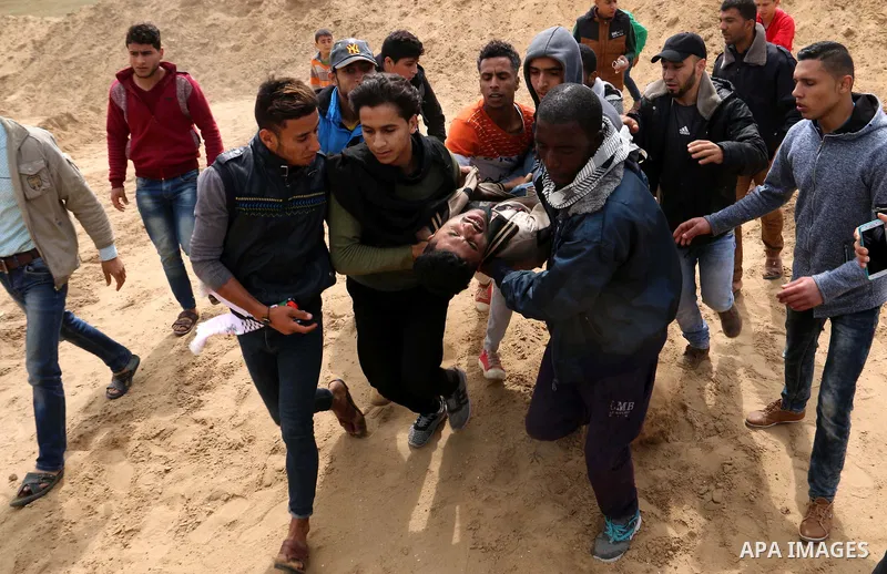 A wounded Palestinian is evacuated during clashes with Israeli security forces during a tent city protest along the Israel border with Gaza, demanding the right to return to their homeland, in al-Bureij in the center of...