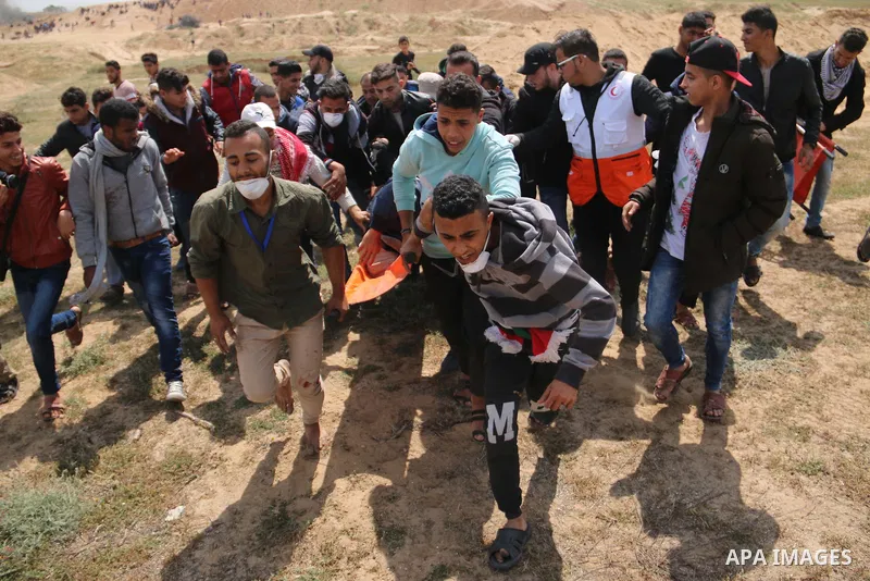 A wounded Palestinian is evacuated during clashes with Israeli security forces during a tent city protest along the Israel border with Gaza, demanding the right to return to their homeland, in al-Bureij in the center of...
