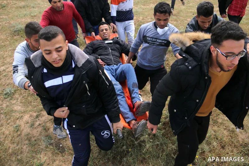 A wounded Palestinian is evacuated during clashes with Israeli security forces during a tent city protest along the Israel border with Gaza, demanding the right to return to their homeland, in al-Bureij in the center of...