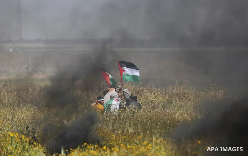 Palestinian protesters take cover during clashes with Israeli security forces in a tent city protest along the Israel border with Gaza, demanding the right to return to their homeland, in Khan Younis in the southern Gaza...