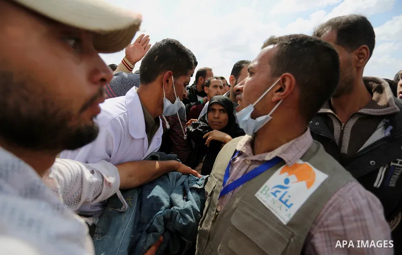 A wounded Palestinian woman is evacuated during clashes with Israeli security forces during a tent city protest along the Israel border with Gaza, demanding the right to return to their homeland, in Khan Younis in the so...