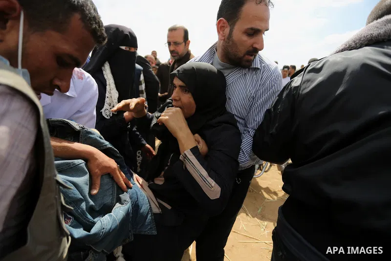A wounded Palestinian woman is evacuated during clashes with Israeli security forces during a tent city protest along the Israel border with Gaza, demanding the right to return to their homeland, in Khan Younis in the so...