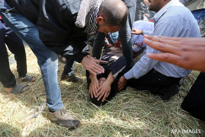 A wounded Palestinian woman is evacuated during clashes with Israeli security forces during a tent city protest along the Israel border with Gaza, demanding the right to return to their homeland, in Khan Younis in the so...