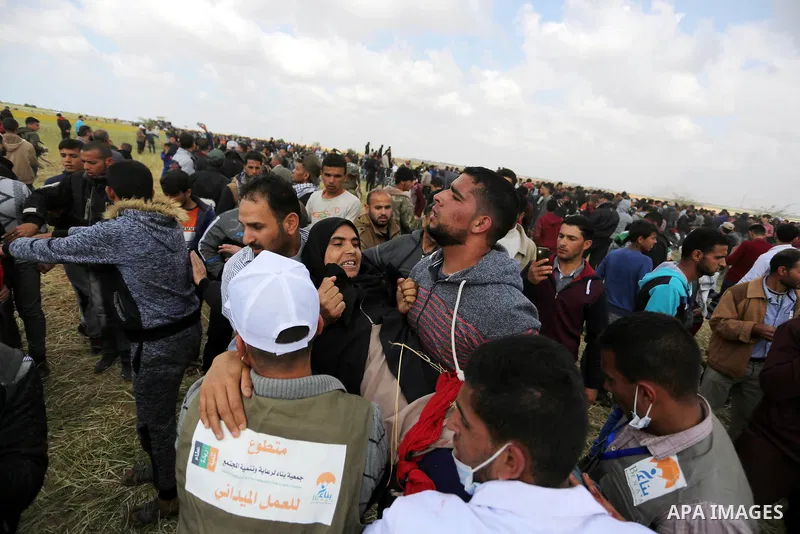 A wounded Palestinian woman is evacuated during clashes with Israeli security forces during a tent city protest along the Israel border with Gaza, demanding the right to return to their homeland, in Khan Younis in the so...
