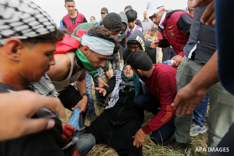 A wounded Palestinian woman is evacuated during clashes with Israeli security forces during a tent city protest along the Israel border with Gaza, demanding the right to return to their homeland, in Khan Younis in the so...