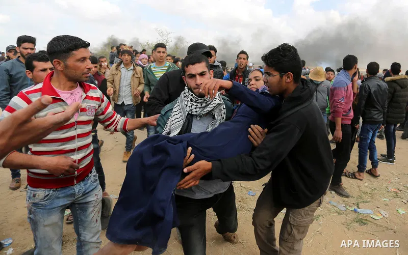 A wounded Palestinian woman is evacuated during clashes with Israeli security forces during a tent city protest along the Israel border with Gaza, demanding the right to return to their homeland, in Khan Younis in the so...