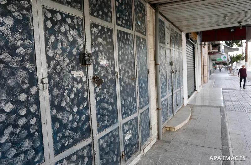 Palestinians walk past closed shops in Gaza City during a general strike, to mourn for the 15 Palestinians who was killed during clashes with Israeli security forces in a tent city protest along the Israel borders with G...