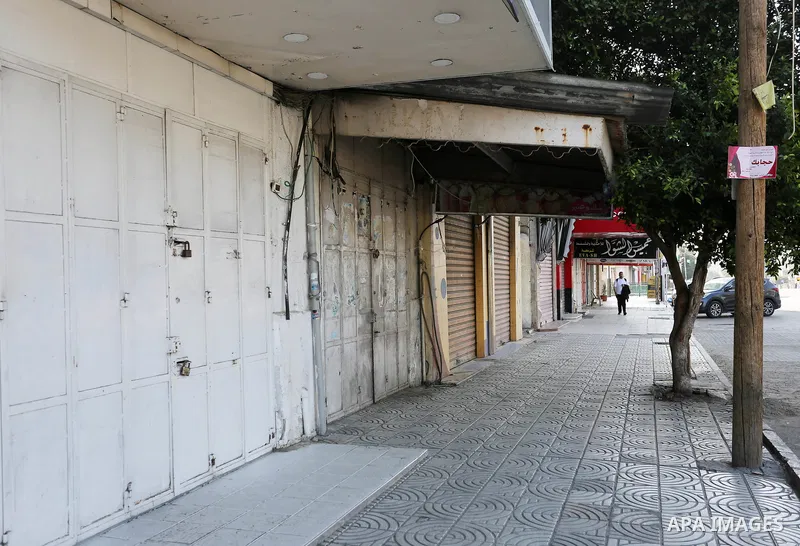 Palestinians walk past closed shops in Gaza City during a general strike, to mourn for the 15 Palestinians who was killed during clashes with Israeli security forces in a tent city protest along the Israel borders with G...