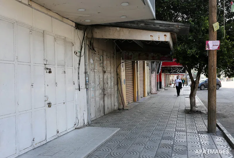 Palestinians walk past closed shops in Gaza City during a general strike, to mourn for the 15 Palestinians who was killed during clashes with Israeli security forces in a tent city protest along the Israel borders with G...