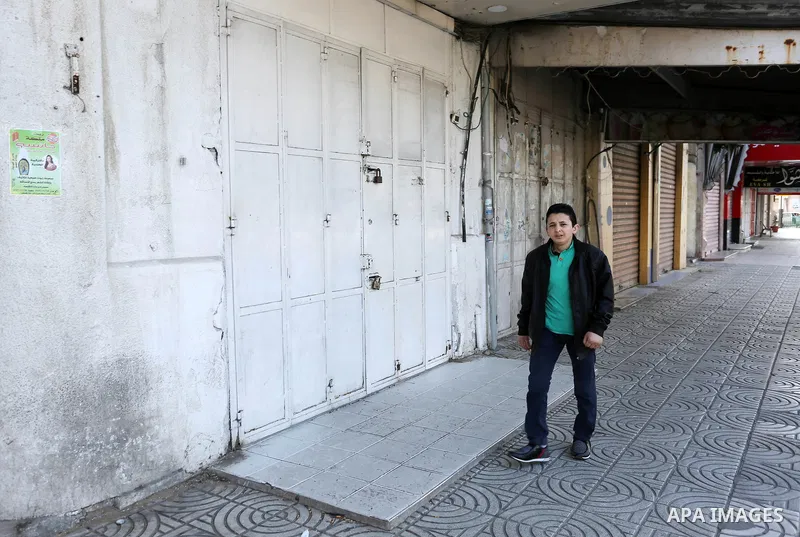 Palestinians walk past closed shops in Gaza City during a general strike, to mourn for the 15 Palestinians who was killed during clashes with Israeli security forces in a tent city protest along the Israel borders with G...