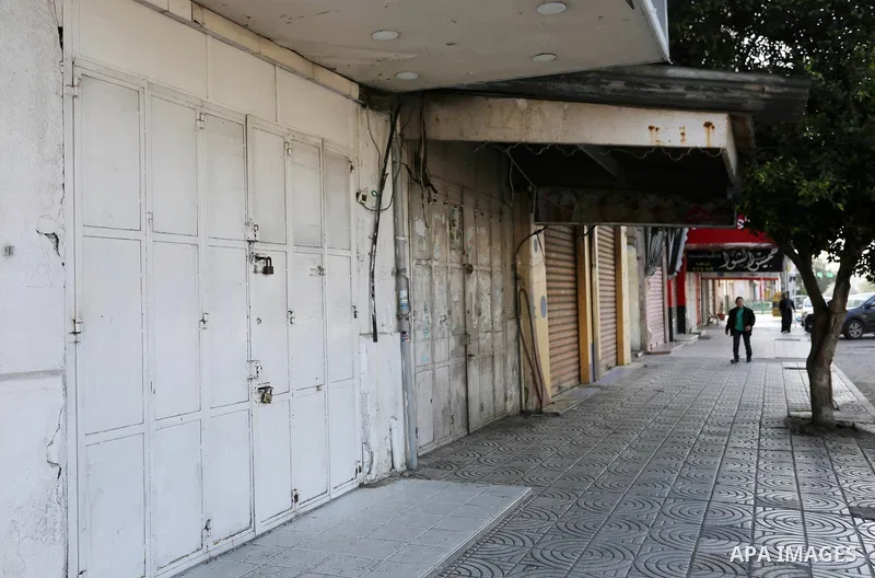 Palestinians walk past closed shops in Gaza City during a general strike, to mourn for the 15 Palestinians who was killed during clashes with Israeli security forces in a tent city protest along the Israel borders with G...
