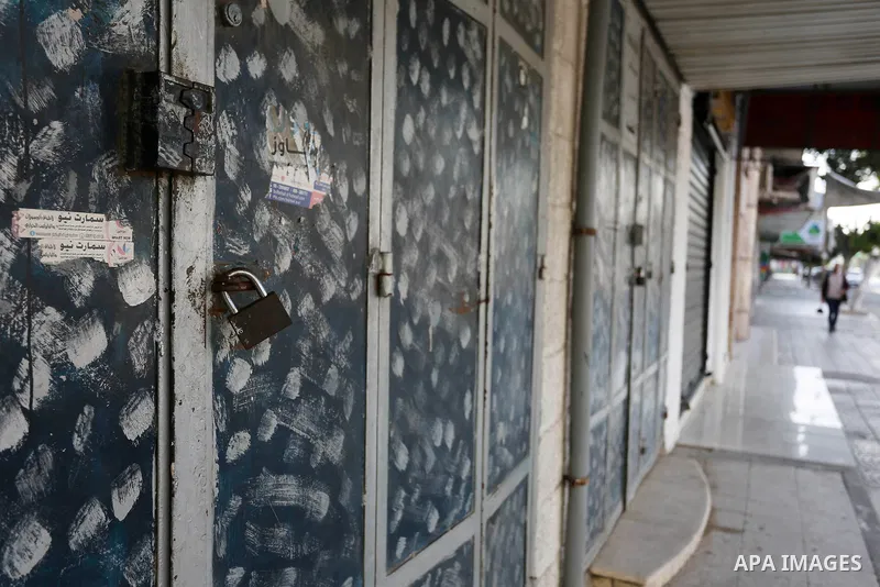 Palestinians walk past closed shops in Gaza City during a general strike, to mourn for the 15 Palestinians who was killed during clashes with Israeli security forces in a tent city protest along the Israel borders with G...