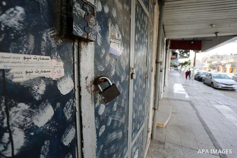 Palestinians walk past closed shops in Gaza City during a general strike, to mourn for the 15 Palestinians who was killed during clashes with Israeli security forces in a tent city protest along the Israel borders with G...
