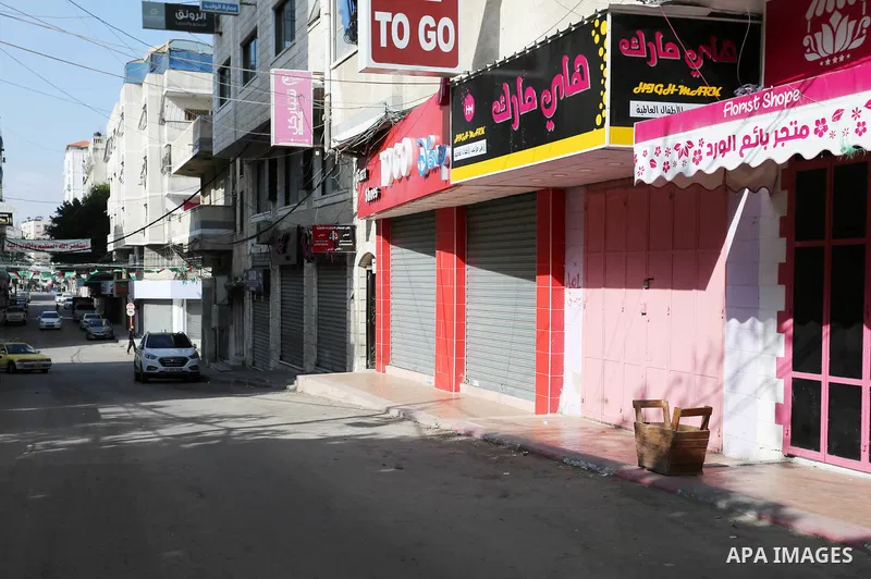 Palestinians walk past closed shops in Gaza City during a general strike, to mourn for the 15 Palestinians who was killed during clashes with Israeli security forces in a tent city protest along the Israel borders with G...