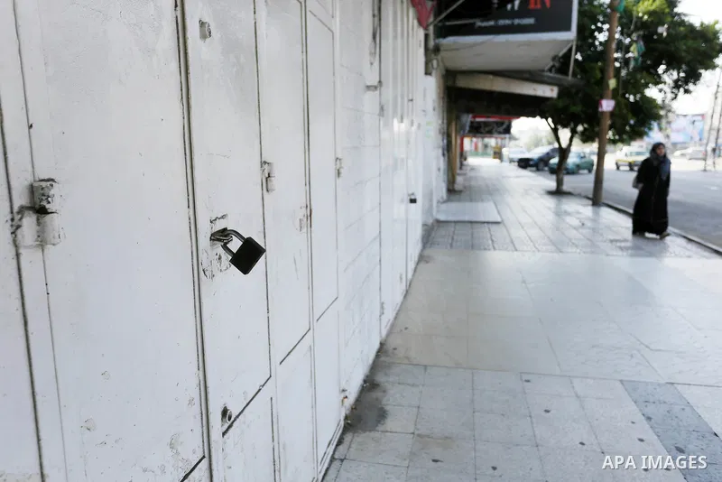 Palestinians walk past closed shops in Gaza City during a general strike, to mourn for the 15 Palestinians who was killed during clashes with Israeli security forces in a tent city protest along the Israel borders with G...
