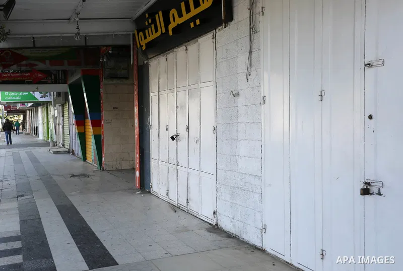 Palestinians walk past closed shops in Gaza City during a general strike, to mourn for the 15 Palestinians who was killed during clashes with Israeli security forces in a tent city protest along the Israel borders with G...
