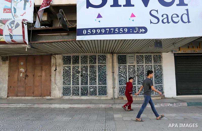 Palestinians walk past closed shops in Gaza City during a general strike, to mourn for the 15 Palestinians who was killed during clashes with Israeli security forces in a tent city protest along the Israel borders with G...