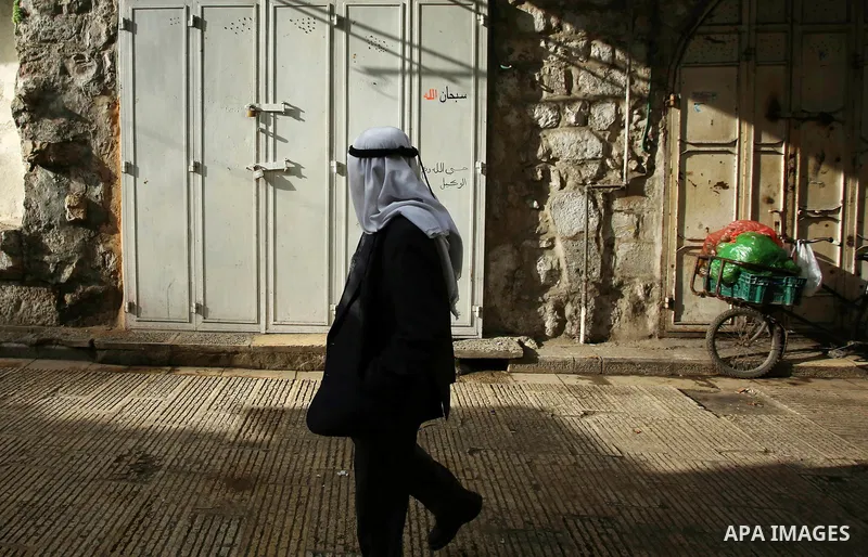 A Palestinian man walks past closed shops in the empty streets of the Israeli occupied West Bank city of Nablus during a general strike called for by local leaders in solidarity with Gaza to mourn for the 15 Palestinians...