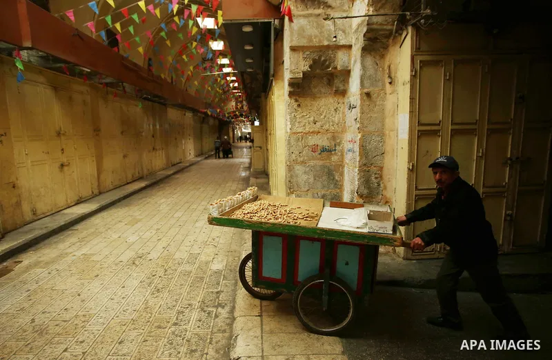 A Palestinians vendor walks past closed shops in the empty streets of the Israeli occupied West Bank city of Nablus during a general strike called for by local leaders in solidarity with Gaza to mourn for the 15 Palestin...