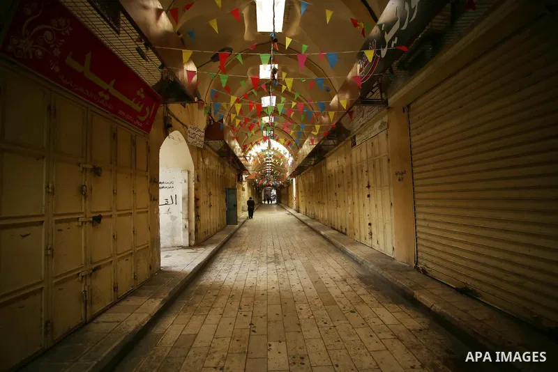 Palestinians walk past closed shops in the empty streets of the Israeli occupied West Bank city of Nablus during a general strike called for by local leaders in solidarity with Gaza to mourn for the 15 Palestinians who w...