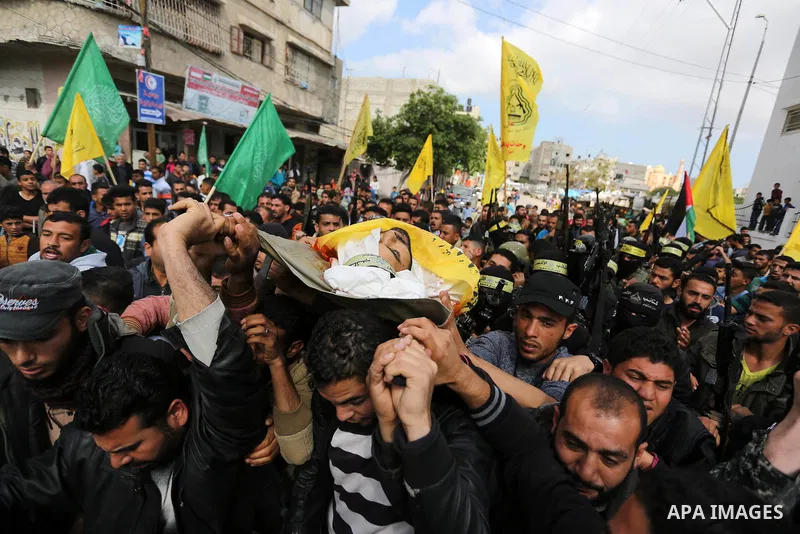 Palestinians carry the body of Hamdan Abu Amsha who was killed a day earlier during clashes with Israeli security forces in a tent city protest along the Israel border with Gaza, demanding the right to return to their ho...
