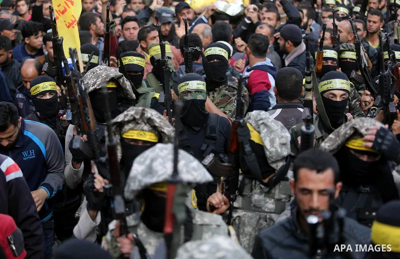Palestinian militants of Al-Aqsa Martyrs' Brigades attend a funeral of Hamdan Abu Amsha who was killed a day earlier during clashes with Israeli security forces in a tent city protest along the Israel border with Gaza, d...