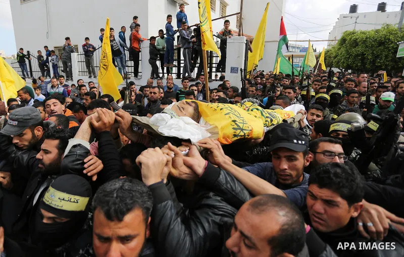 Palestinians carry the body of Hamdan Abu Amsha who was killed a day earlier during clashes with Israeli security forces in a tent city protest along the Israel border with Gaza, demanding the right to return to their ho...