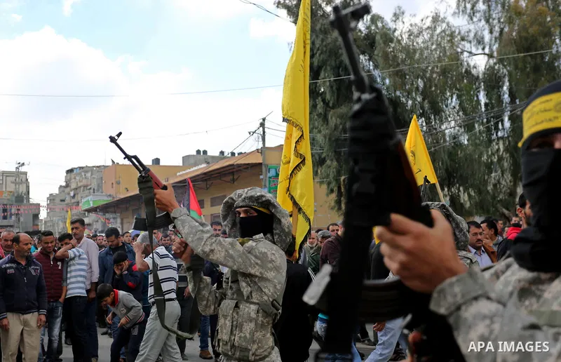 Palestinian militants of Al-Aqsa Martyrs' Brigades attend a funeral of Hamdan Abu Amsha who was killed a day earlier during clashes with Israeli security forces in a tent city protest along the Israel border with Gaza, d...