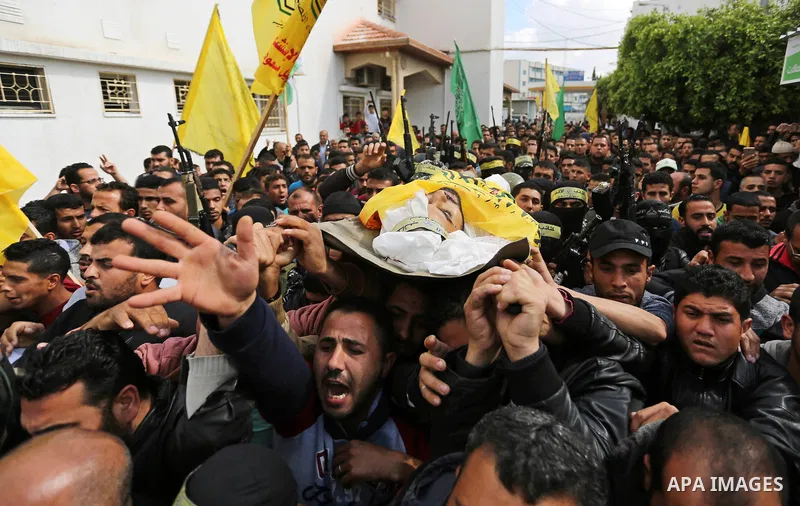 Palestinians carry the body of Hamdan Abu Amsha who was killed a day earlier during clashes with Israeli security forces in a tent city protest along the Israel border with Gaza, demanding the right to return to their ho...