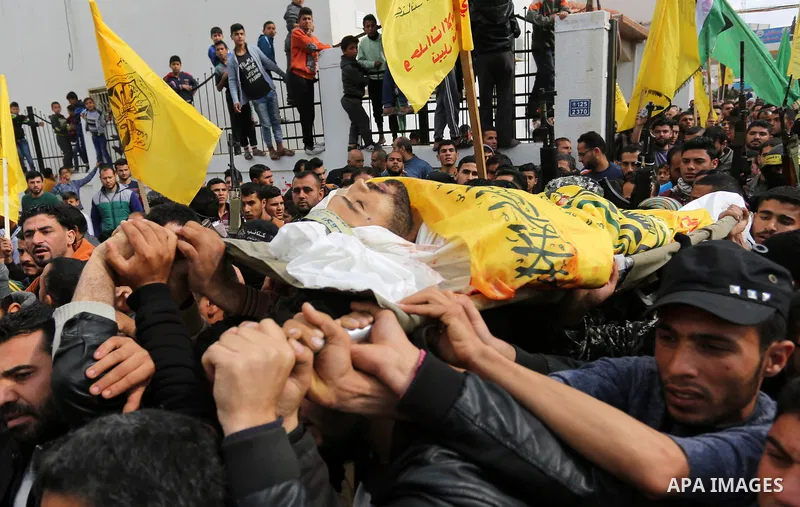 Palestinians carry the body of Hamdan Abu Amsha who was killed a day earlier during clashes with Israeli security forces in a tent city protest along the Israel border with Gaza, demanding the right to return to their ho...