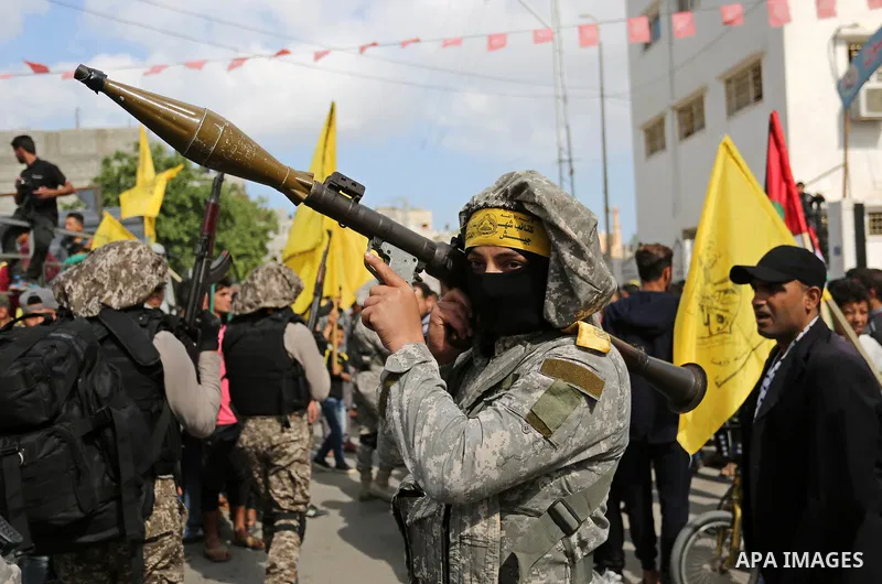 Palestinian militants of Al-Aqsa Martyrs' Brigades attend a funeral of Hamdan Abu Amsha who was killed a day earlier during clashes with Israeli security forces in a tent city protest along the Israel border with Gaza, d...
