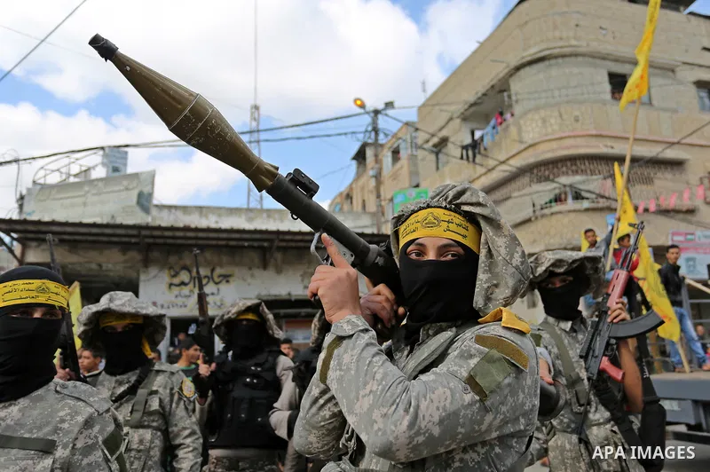 Palestinian militants of Al-Aqsa Martyrs' Brigades attend a funeral of Hamdan Abu Amsha who was killed a day earlier during clashes with Israeli security forces in a tent city protest along the Israel border with Gaza, d...