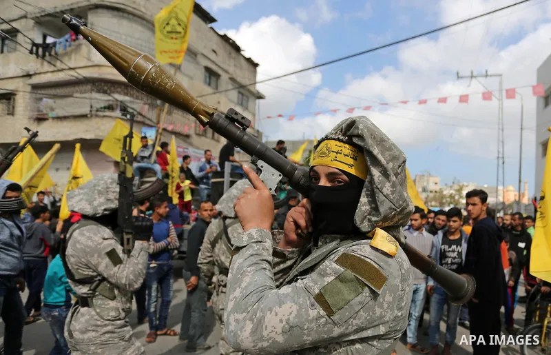 Palestinian militants of Al-Aqsa Martyrs' Brigades attend a funeral of Hamdan Abu Amsha who was killed a day earlier during clashes with Israeli security forces in a tent city protest along the Israel border with Gaza, d...