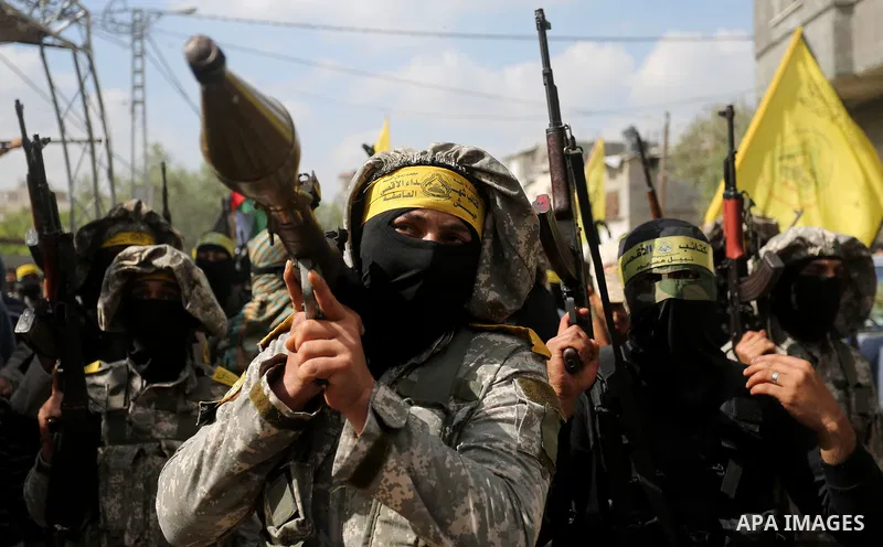 Palestinian militants of Al-Aqsa Martyrs' Brigades attend a funeral of Hamdan Abu Amsha who was killed a day earlier during clashes with Israeli security forces in a tent city protest along the Israel border with Gaza, d...