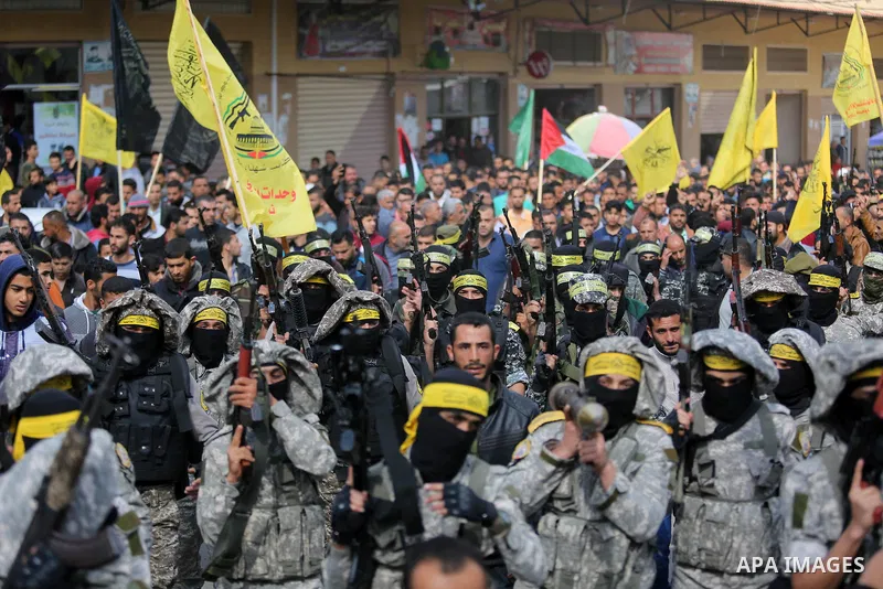 Palestinian militants of Al-Aqsa Martyrs' Brigades attend a funeral of Hamdan Abu Amsha who was killed a day earlier during clashes with Israeli security forces in a tent city protest along the Israel border with Gaza, d...
