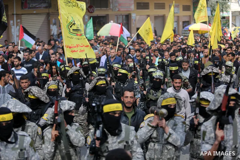 Palestinian militants of Al-Aqsa Martyrs' Brigades attend a funeral of Hamdan Abu Amsha who was killed a day earlier during clashes with Israeli security forces in a tent city protest along the Israel border with Gaza, d...