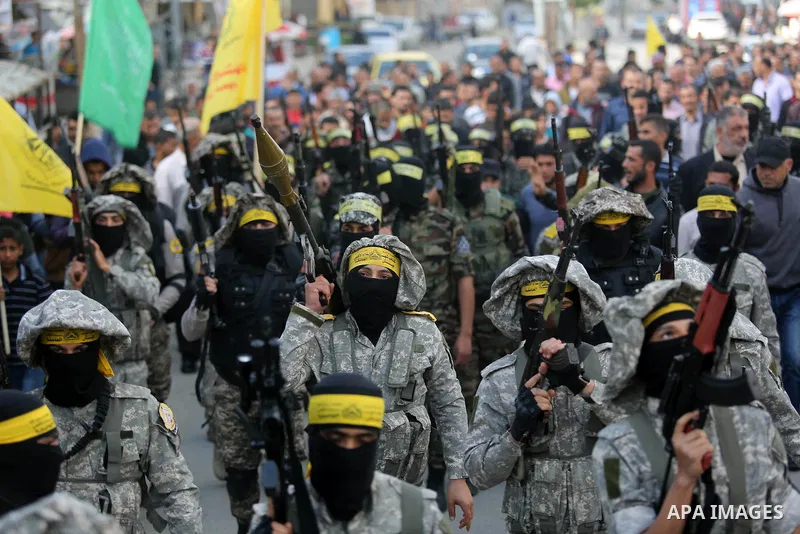 Palestinian militants of Al-Aqsa Martyrs' Brigades attend a funeral of Hamdan Abu Amsha who was killed a day earlier during clashes with Israeli security forces in a tent city protest along the Israel border with Gaza, d...