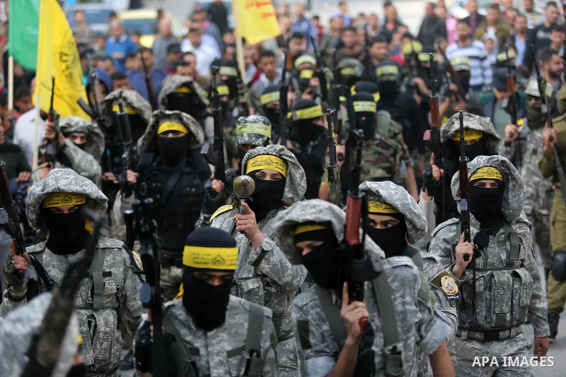 Palestinian militants of Al-Aqsa Martyrs' Brigades attend a funeral of Hamdan Abu Amsha who was killed a day earlier during clashes with Israeli security forces in a tent city protest along the Israel border with Gaza, d...