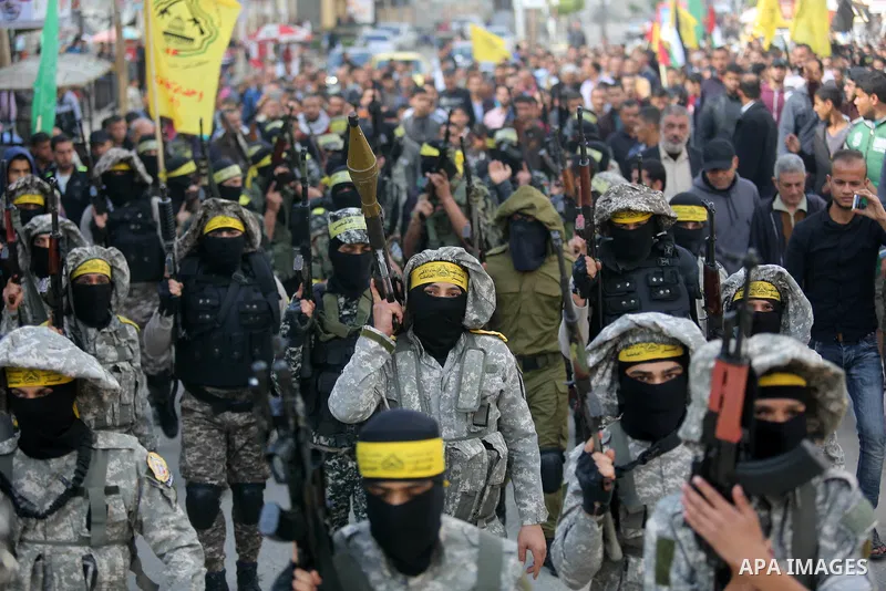 Palestinian militants of Al-Aqsa Martyrs' Brigades attend a funeral of Hamdan Abu Amsha who was killed a day earlier during clashes with Israeli security forces in a tent city protest along the Israel border with Gaza, d...