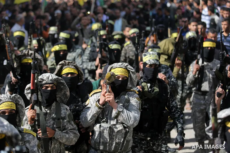 Palestinian militants of Al-Aqsa Martyrs' Brigades attend a funeral of Hamdan Abu Amsha who was killed a day earlier during clashes with Israeli security forces in a tent city protest along the Israel border with Gaza, d...