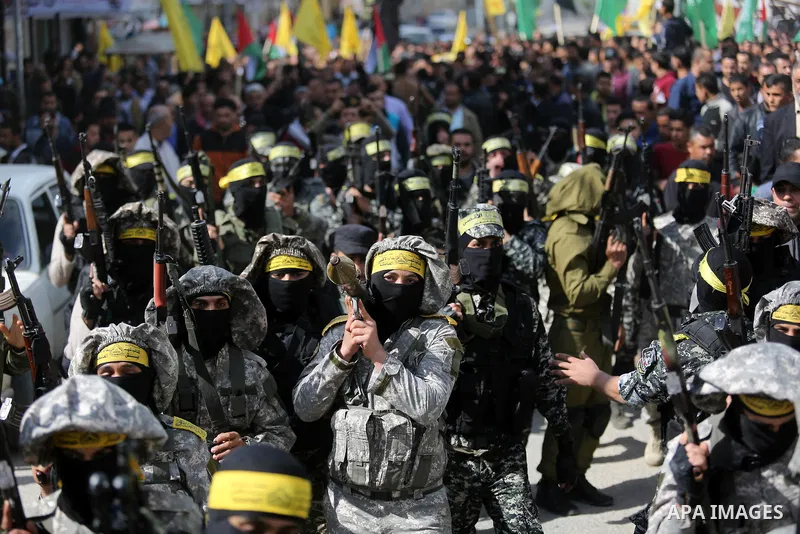Palestinian militants of Al-Aqsa Martyrs' Brigades attend a funeral of Hamdan Abu Amsha who was killed a day earlier during clashes with Israeli security forces in a tent city protest along the Israel border with Gaza, d...