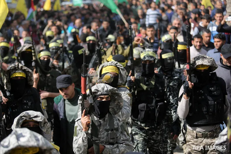 Palestinian militants of Al-Aqsa Martyrs' Brigades attend a funeral of Hamdan Abu Amsha who was killed a day earlier during clashes with Israeli security forces in a tent city protest along the Israel border with Gaza, d...