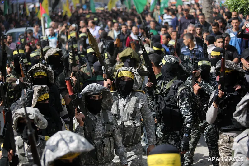 Palestinian militants of Al-Aqsa Martyrs' Brigades attend a funeral of Hamdan Abu Amsha who was killed a day earlier during clashes with Israeli security forces in a tent city protest along the Israel border with Gaza, d...