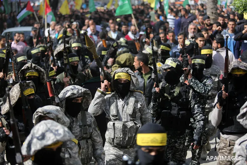 Palestinian militants of Al-Aqsa Martyrs' Brigades attend a funeral of Hamdan Abu Amsha who was killed a day earlier during clashes with Israeli security forces in a tent city protest along the Israel border with Gaza, d...