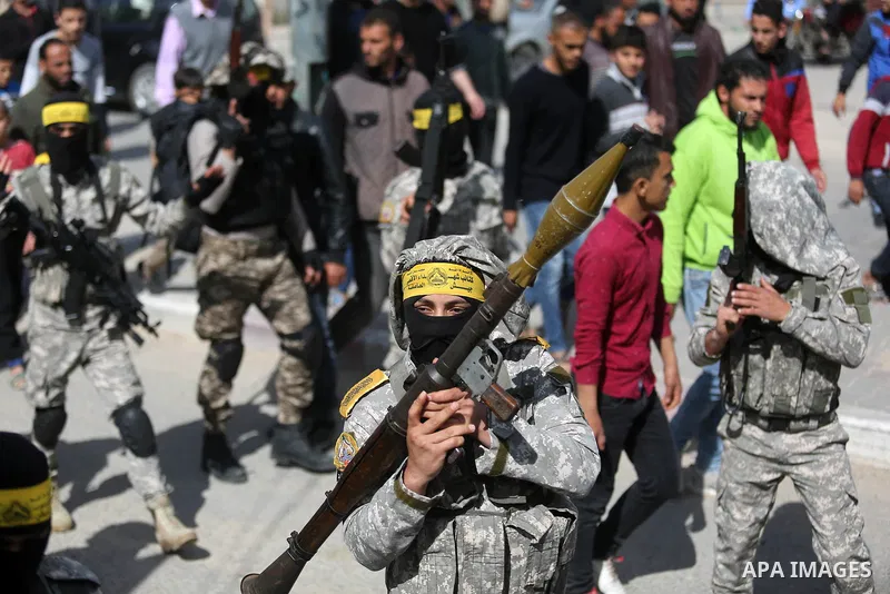 Palestinian militants of Al-Aqsa Martyrs' Brigades attend a funeral of Hamdan Abu Amsha who was killed a day earlier during clashes with Israeli security forces in a tent city protest along the Israel border with Gaza, d...