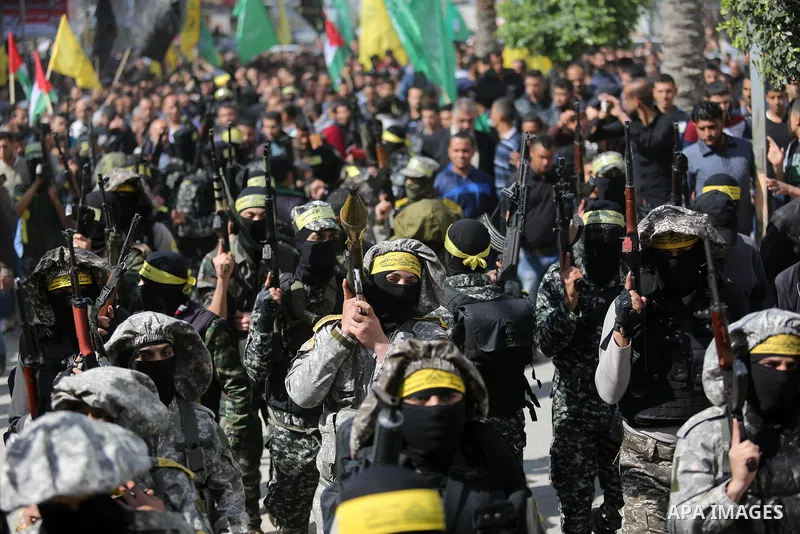 Palestinian militants of Al-Aqsa Martyrs' Brigades attend a funeral of Hamdan Abu Amsha who was killed a day earlier during clashes with Israeli security forces in a tent city protest along the Israel border with Gaza, d...