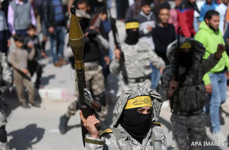 Palestinian militants of Al-Aqsa Martyrs' Brigades attend a funeral of Hamdan Abu Amsha who was killed a day earlier during clashes with Israeli security forces in a tent city protest along the Israel border with Gaza, d...