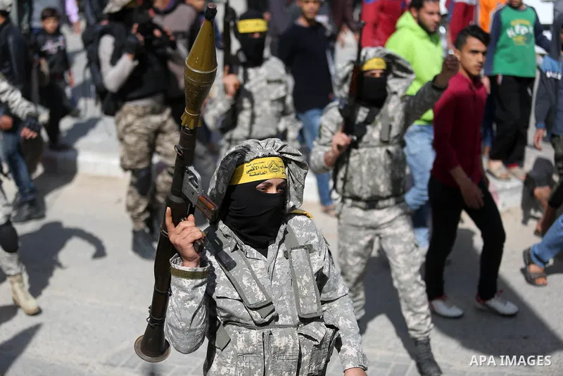 Palestinian militants of Al-Aqsa Martyrs' Brigades attend a funeral of Hamdan Abu Amsha who was killed a day earlier during clashes with Israeli security forces in a tent city protest along the Israel border with Gaza, d...