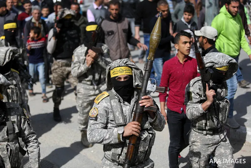Palestinian militants of Al-Aqsa Martyrs' Brigades attend a funeral of Hamdan Abu Amsha who was killed a day earlier during clashes with Israeli security forces in a tent city protest along the Israel border with Gaza, d...
