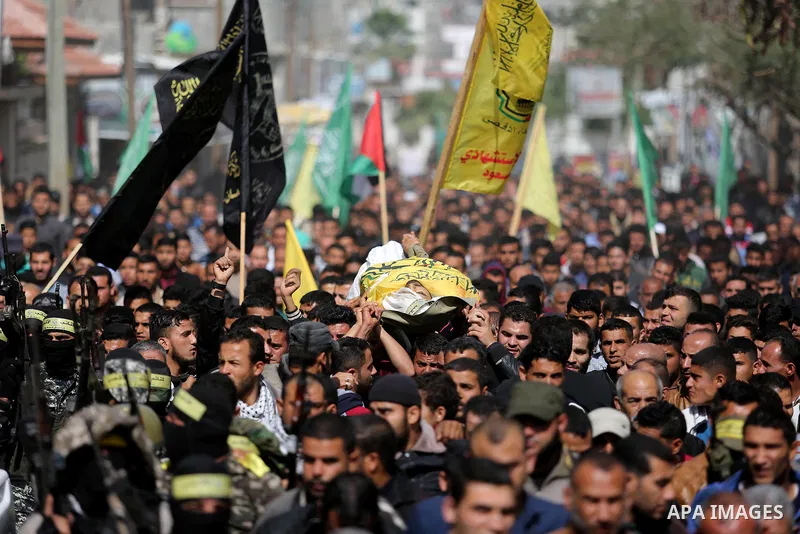 Palestinians carry the body of Hamdan Abu Amsha who was killed a day earlier during clashes with Israeli security forces in a tent city protest along the Israel border with Gaza, demanding the right to return to their ho...